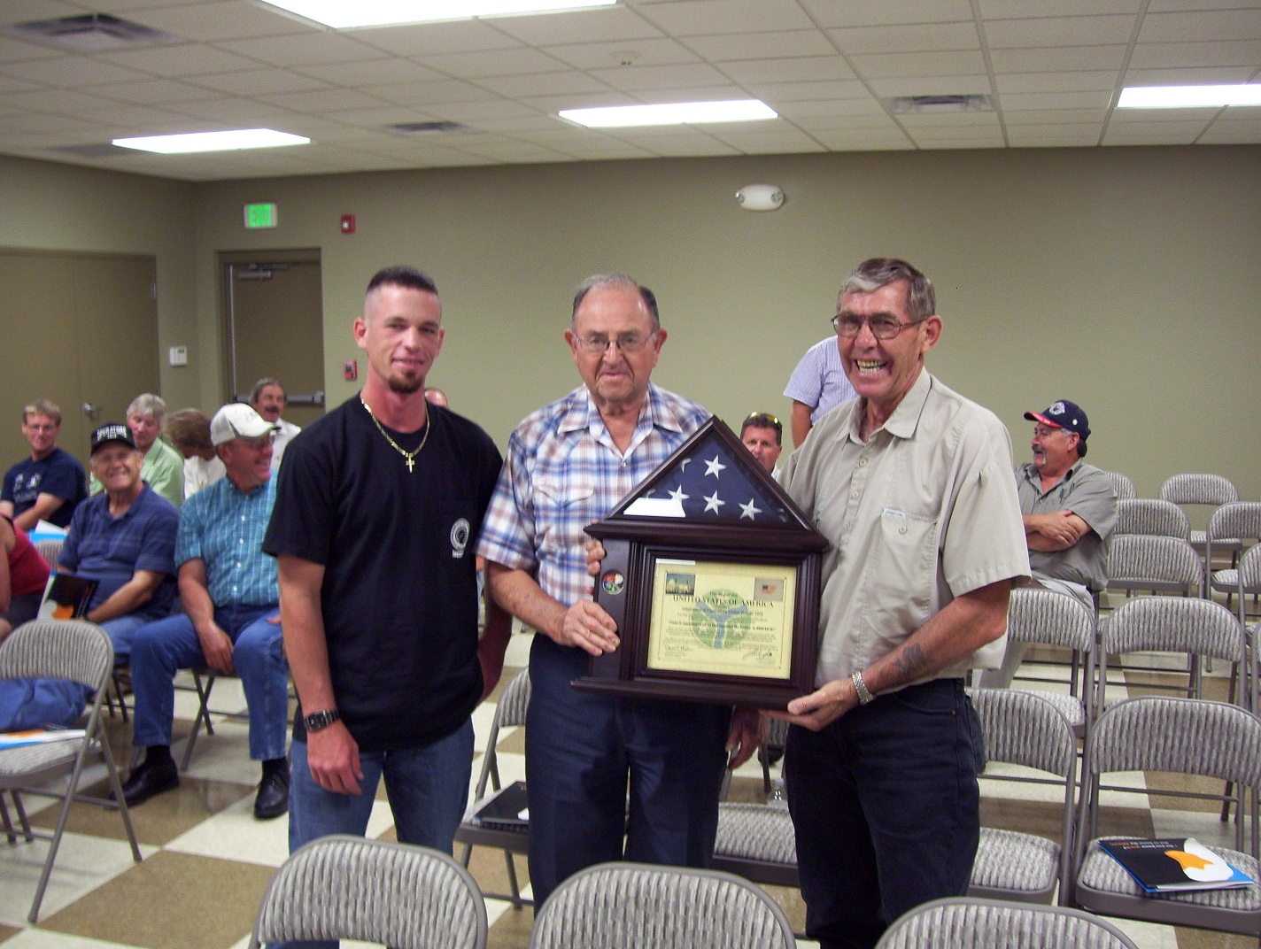 Member, Sgt. James Knight presenting retirees Ray Boggs and Les Berry with American Flag and certificate from Iraq